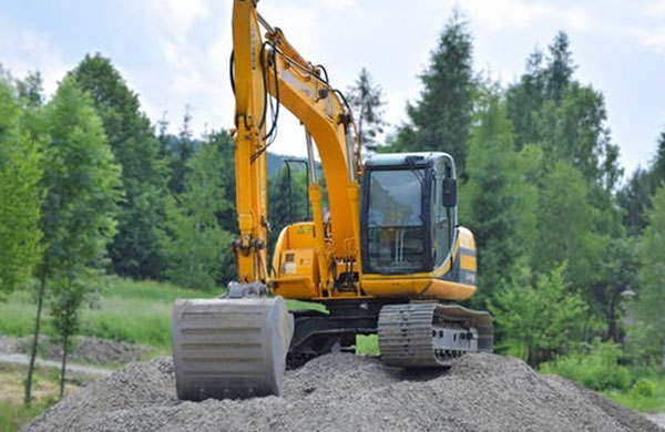 Excavator Atop a Mound of Dirt